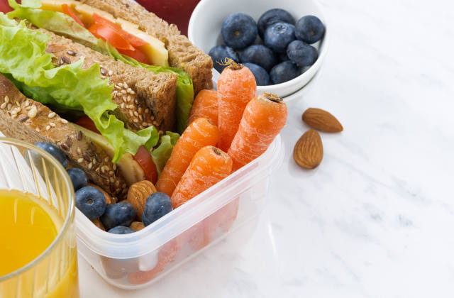 lunch box with sandwich and vegetables