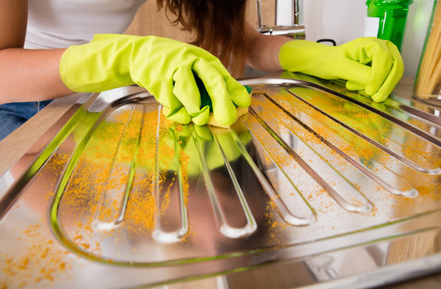 Woman cleaning a steel sink