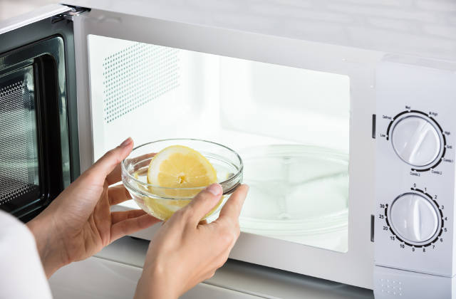 Woman putting bowl of water in the microwave